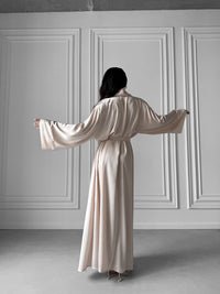 Step into a realm of refined luxury with our Long Silky Robe showcasing a Shawl Collar and enticing side slits. Crafted in sumptuous silky fabric, this robe is designed to elevate your loungewear experience with unparalleled comfort and style. Okiya Studio