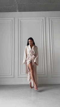 Okiya Studio. Experience pure opulence in our Long Silky Robe with Shawl Collar. Immerse yourself in the silky embrace of this luxurious robe featuring side slits, designed for those seeking the epitome of comfort and chic allure.
