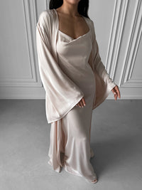 Elevate your loungewear collection with our Kimono Robe and Nightgown Set, a perfect synthesis of elegance and affordability. Crafted in sumptuous silky fabric, the Kimono Robe features a tie waist, open front, and kimono sleeves, perfectly complementing the Nightgown with adjustable straps, A-line design, fitted waist, open back, and floor length. Immerse yourself in sophistication and enjoy special savings when you invest in this harmonious ensemble. Ideal for wedding mornings, bridal robes