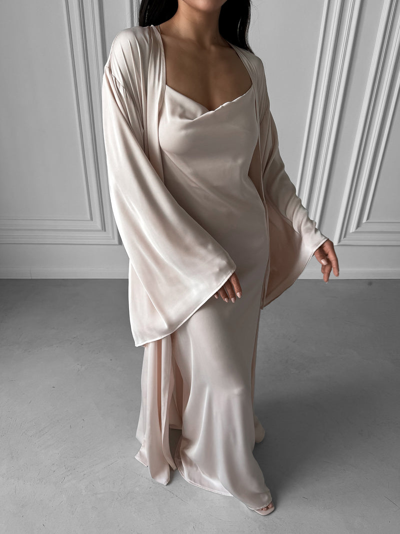 Elevate your loungewear collection with our Kimono Robe and Nightgown Set, a perfect synthesis of elegance and affordability. Crafted in sumptuous silky fabric, the Kimono Robe features a tie waist, open front, and kimono sleeves, perfectly complementing the Nightgown with adjustable straps, A-line design, fitted waist, open back, and floor length. Immerse yourself in sophistication and enjoy special savings when you invest in this harmonious ensemble. Ideal for wedding mornings, bridal robes