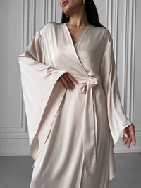 Kimono Robe and Nightgown Set, a harmonious pairing that encapsulates both sophistication and cost-effectiveness. The Kimono Robe, with its tie waist, open front, and kimono sleeves, perfectly complements the Nightgown, featuring adjustable straps, A-line design, fitted waist, open back, and floor length. Immerse yourself in the luxurious feel of silky fabric and revel in the special savings that come with acquiring this enchanting set. Okiya Studio